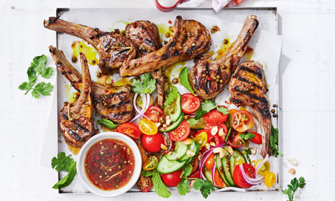 A table of lamb cutlets and salad with a thai dressing
